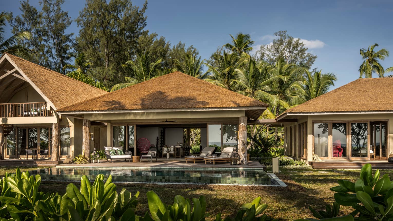 Airy tropical accommodations surrounded by palm trees, with plunge pools