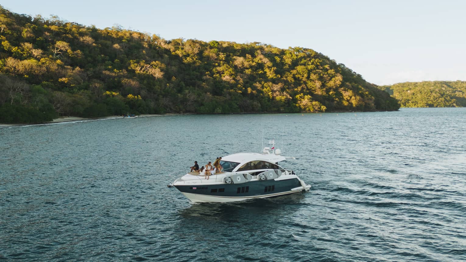 Power boat on water near green hills