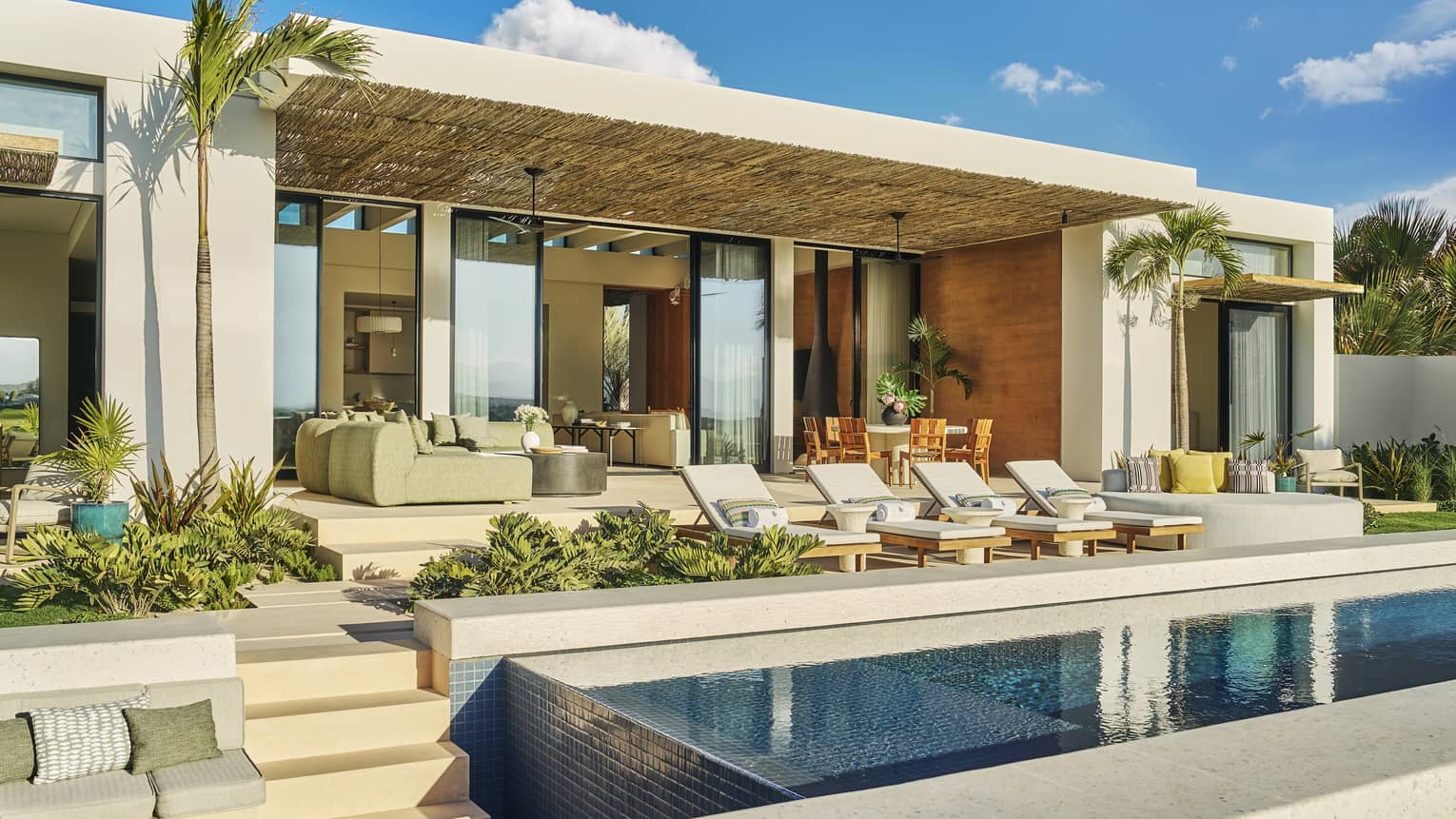Luxury residence villa with pool and four lounge chairs, contemporary pool terrace in Los Cabos