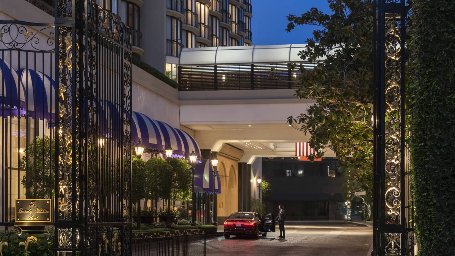 A gate with a golden symbol on top leading to a hotel.