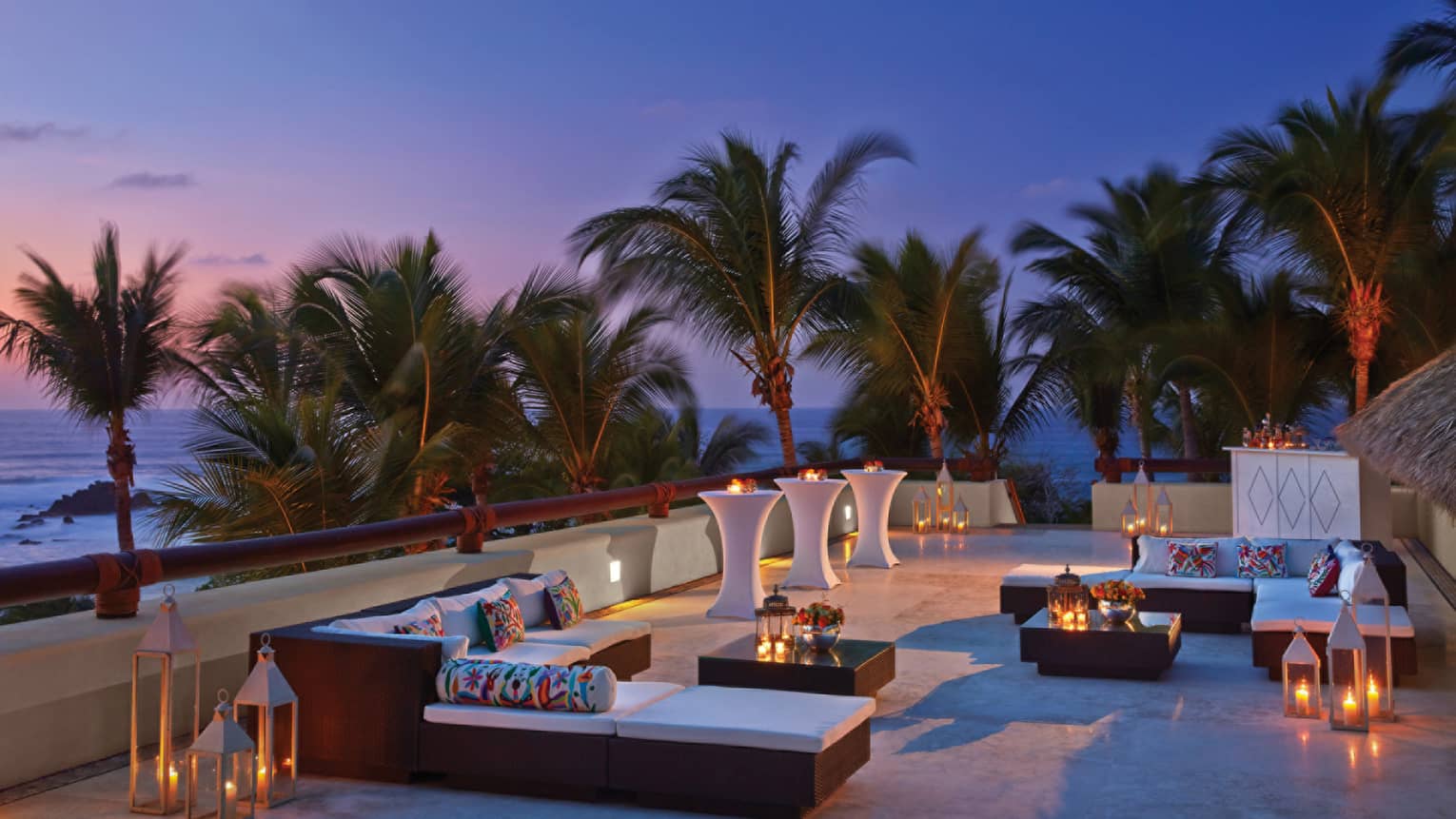 Trendy outdoor lounge at dusk, overlooking the beach