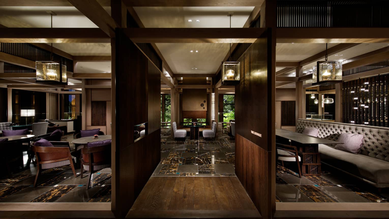 The Lounge dark wood walls, beams, black marble floors, thick glass chandeliers