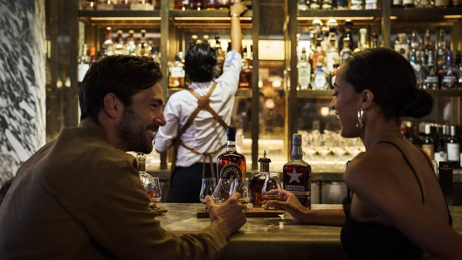 A couple enjoys cocktails at a modern bar