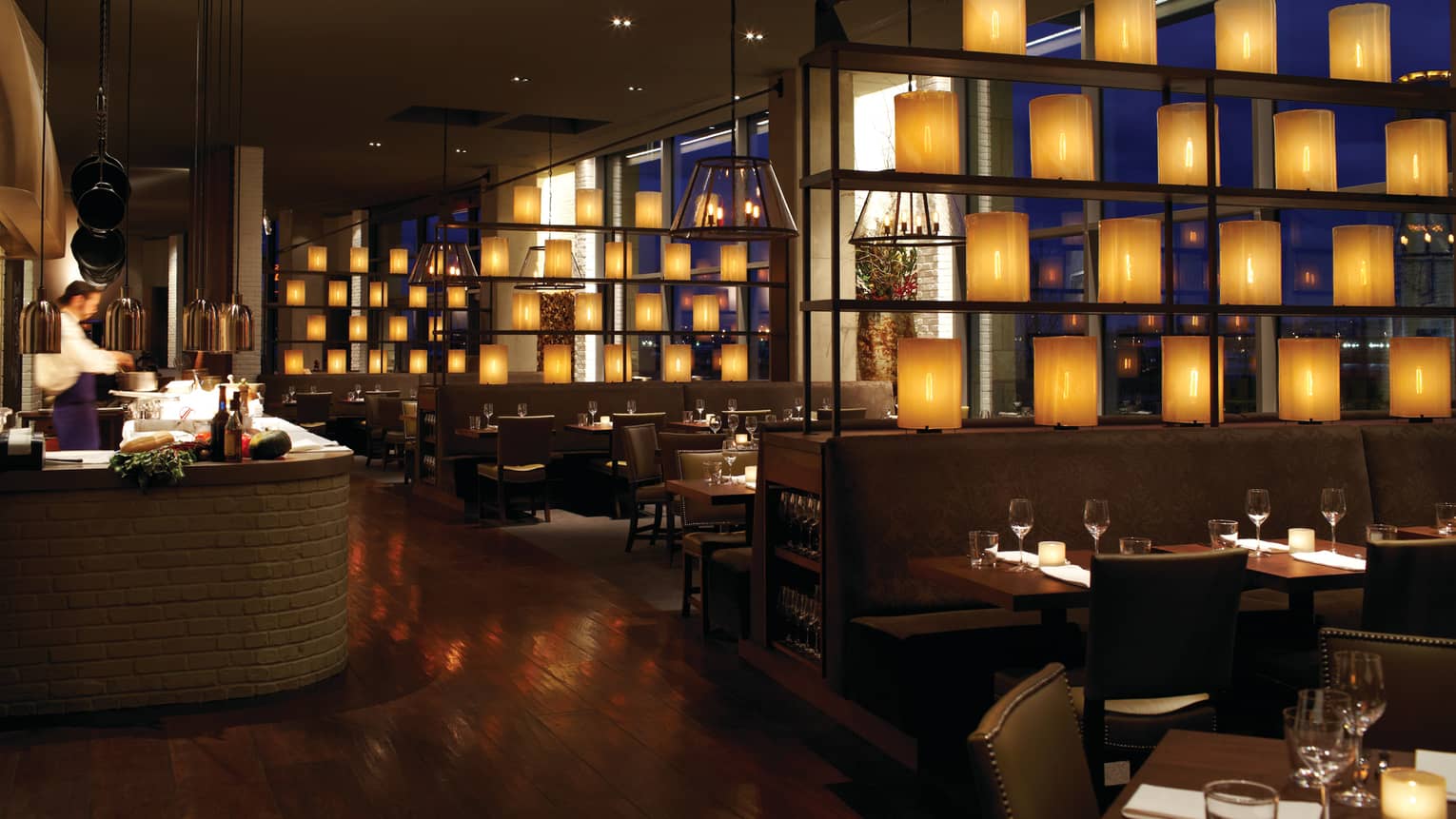 Wit and Wisdom with open kitchen, dark wood decor, glowing lanterns dividing dining room