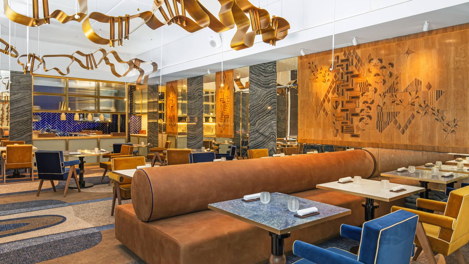 Modern dining area with gold, blue and deep camel accents and art flanking walls and ceiling