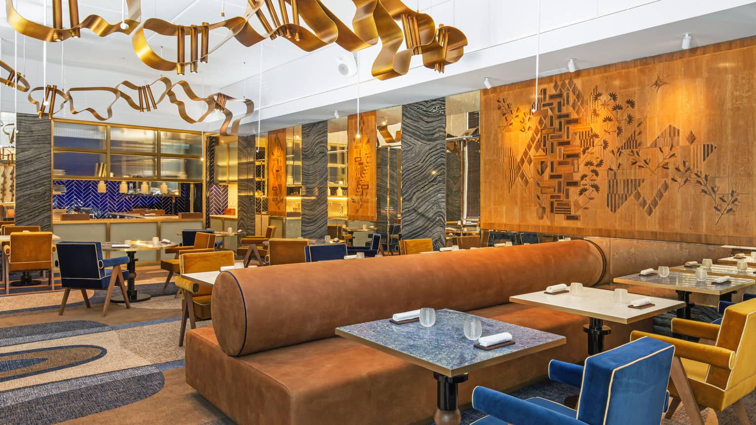 Modern dining area with gold, blue and deep camel accents and art flanking walls and ceiling