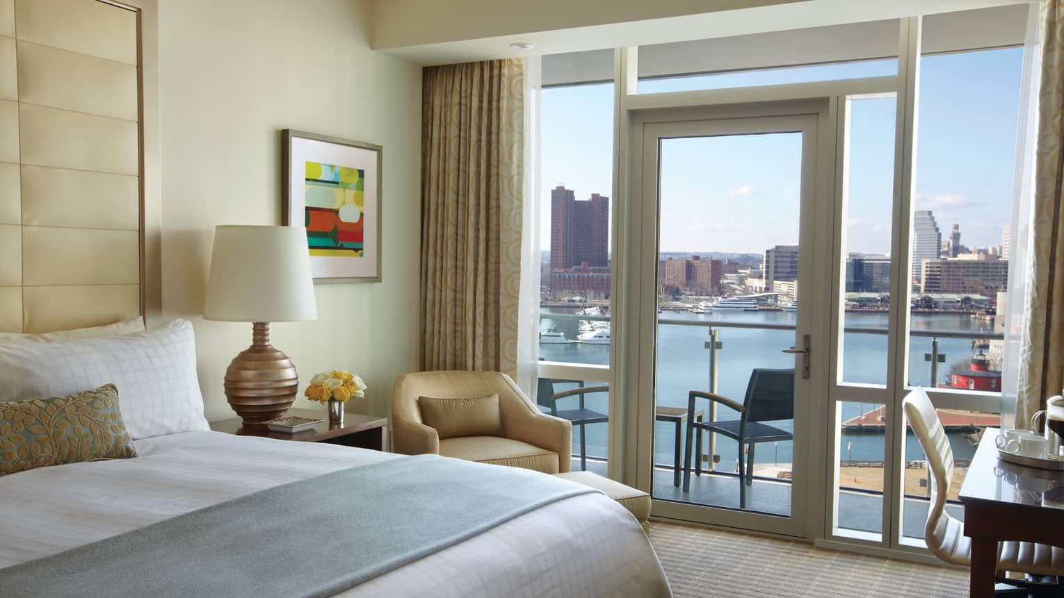 A luxurious king-size bed with plush bedding, a comfortable armchair and a large window offering stunning river views .