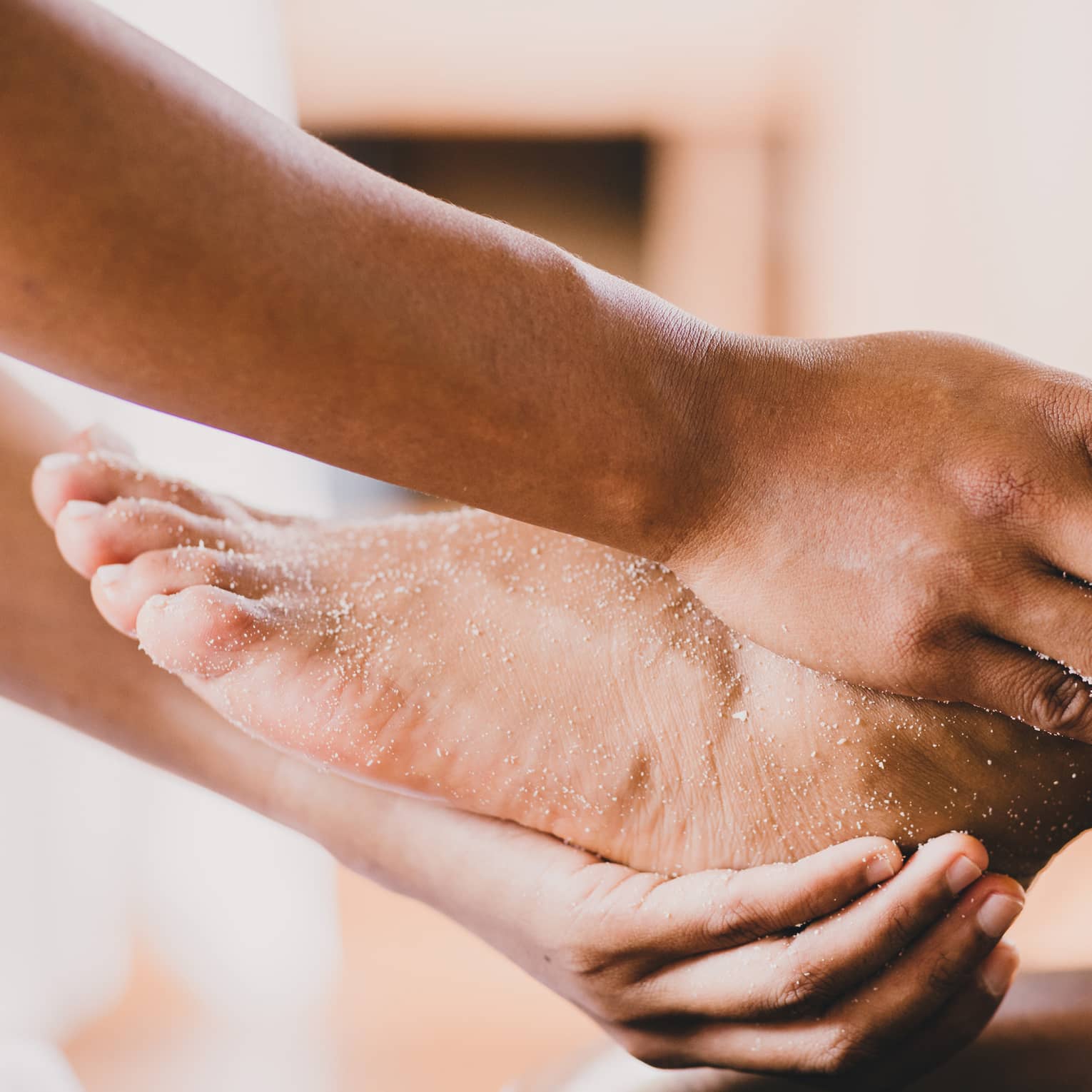 Hands hold a person's foot and ankle in a spa