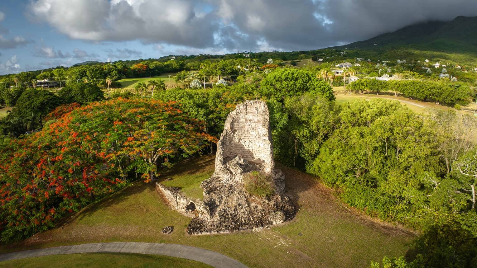 An old structure near plants on a golf course.