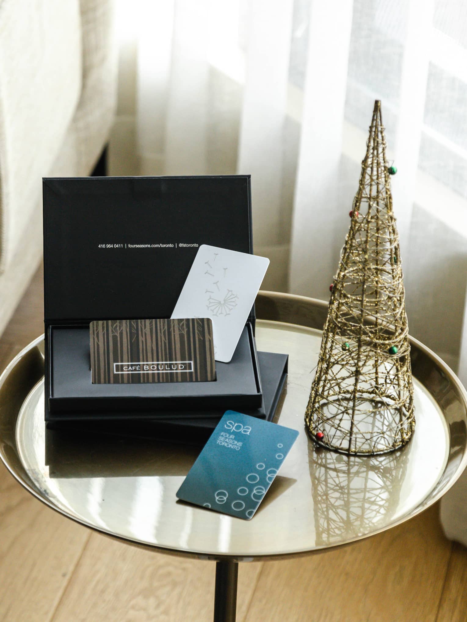 Four Seasons gift card on table with small decorative Christmas tree