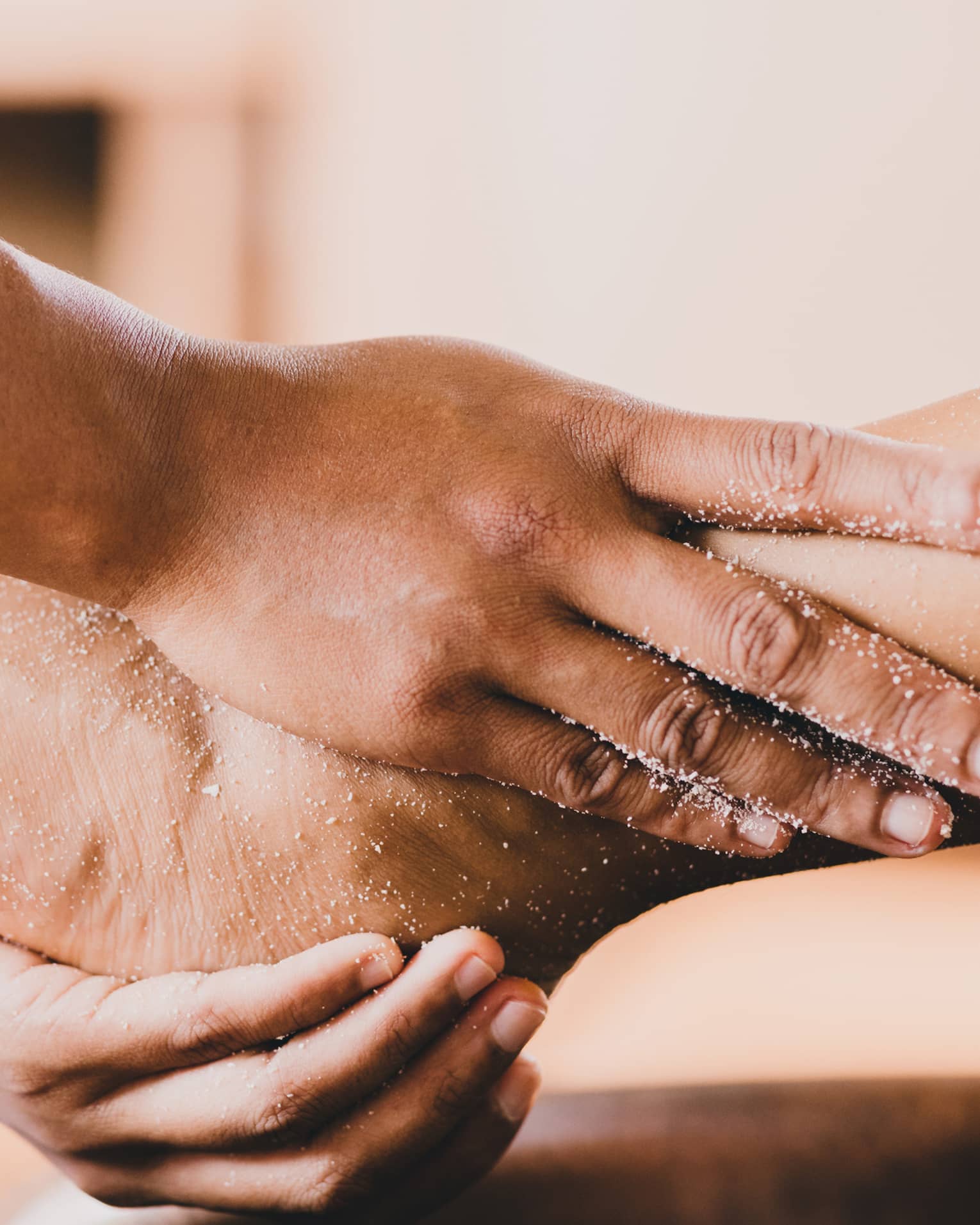Hands hold a person's foot and ankle in a spa