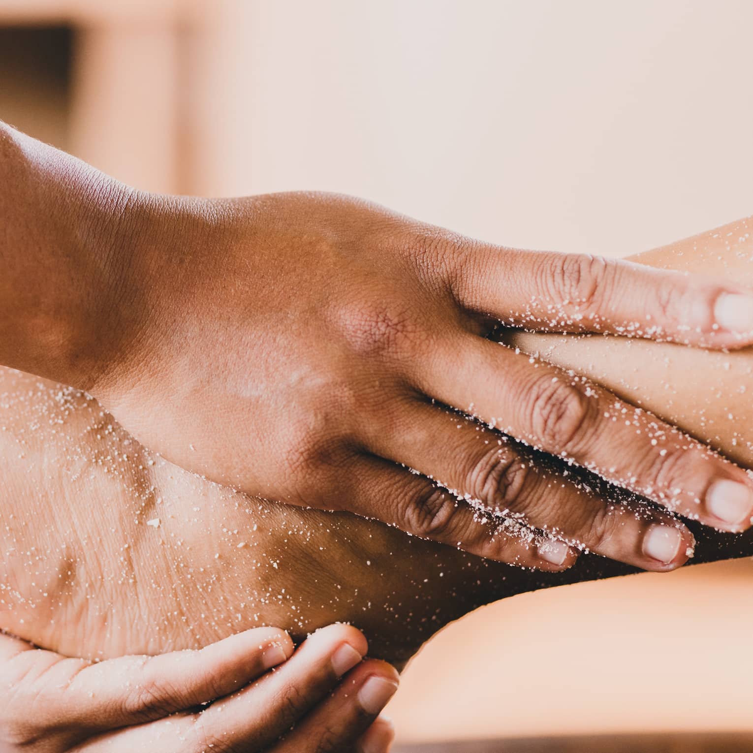 Hands hold a person's foot and ankle in a spa