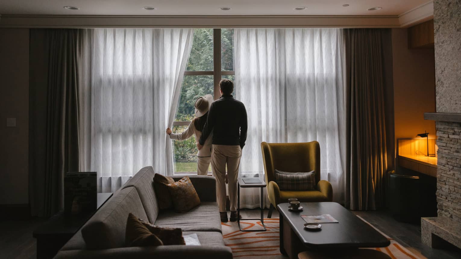 Man and woman looking out the window of their residence