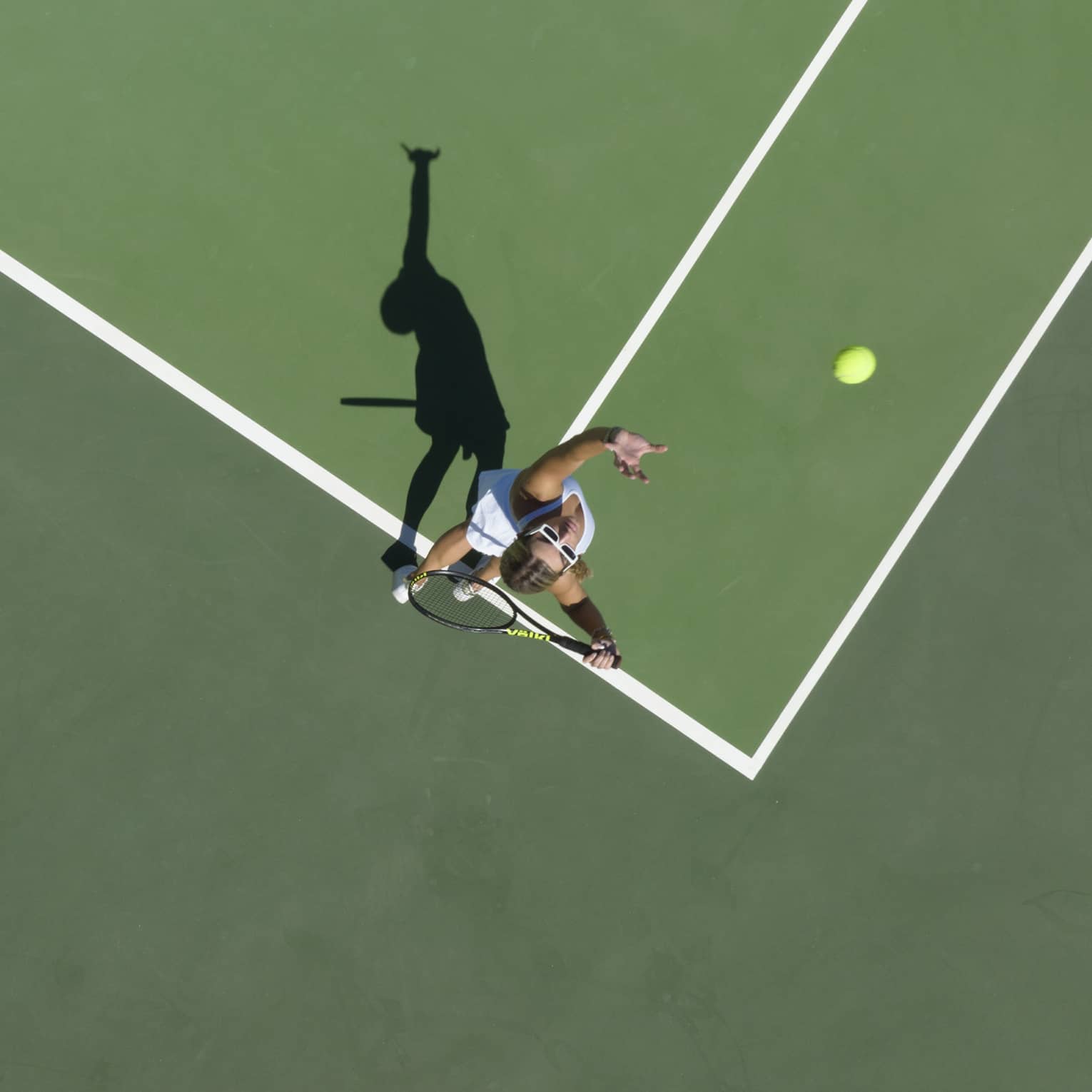 Aerial view of a tennis player mid serve