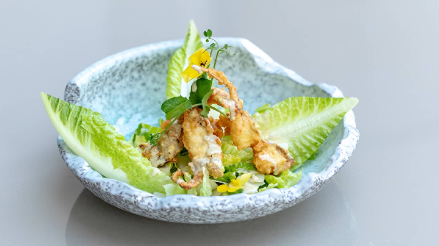 Ceasar Salad with Soft Shell Crab plated in an organic-shaped light-grey stoneware bowl