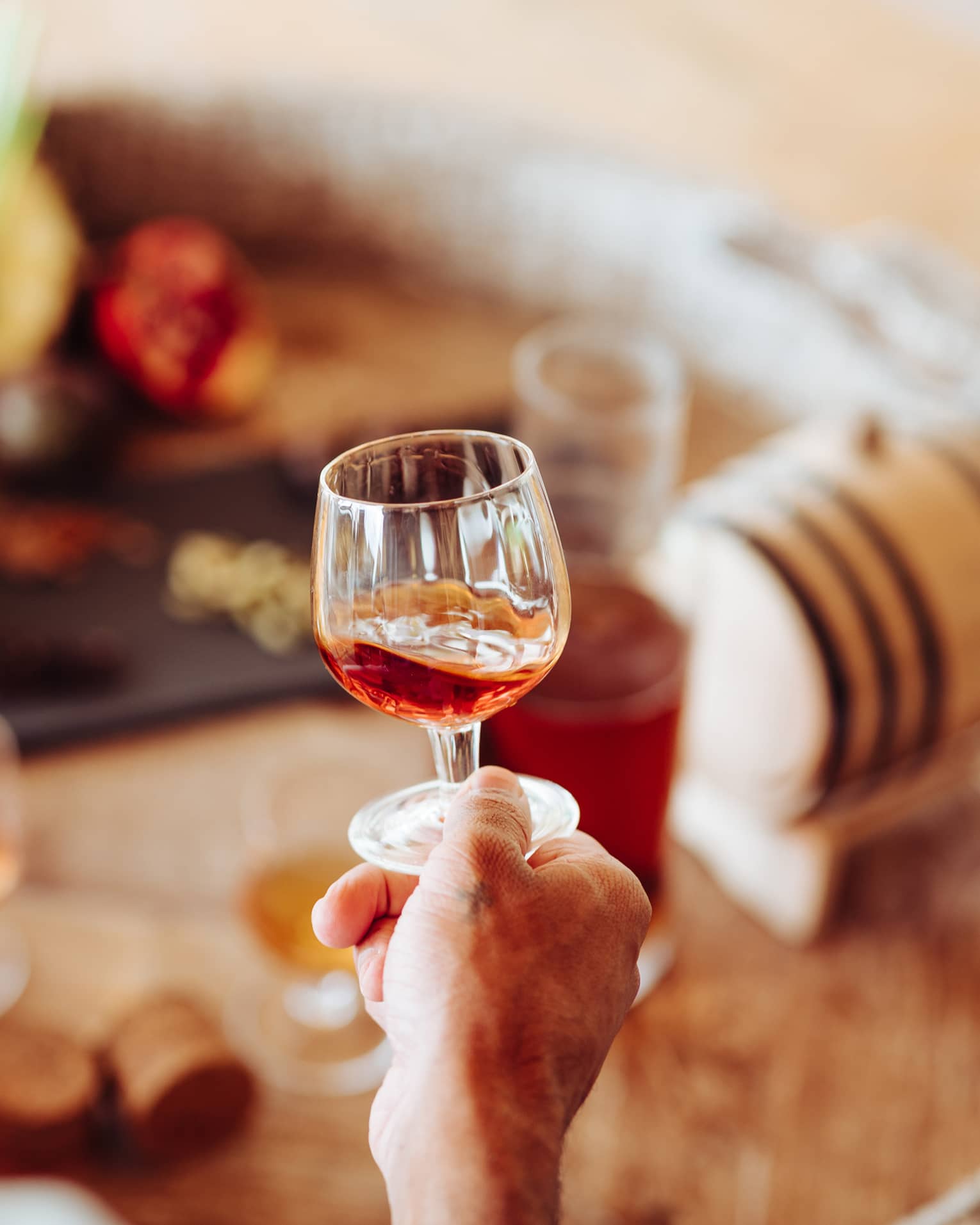 A person holding a clear glass of rum 