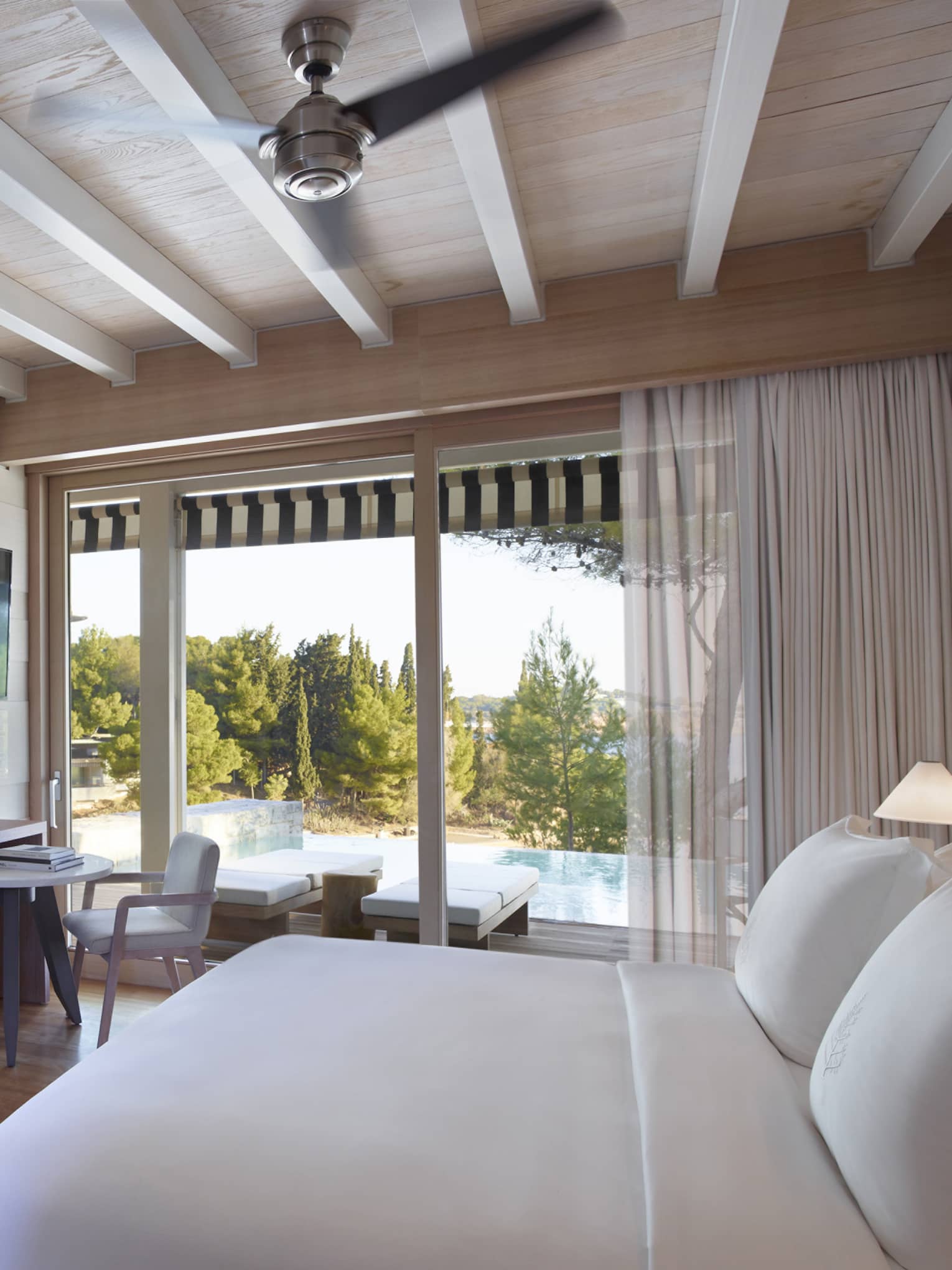 Bungalow Sea View with Pool, white King bed, mirrored doors to bathroom, floor-to-ceiling window overlooking pool, desk and chair