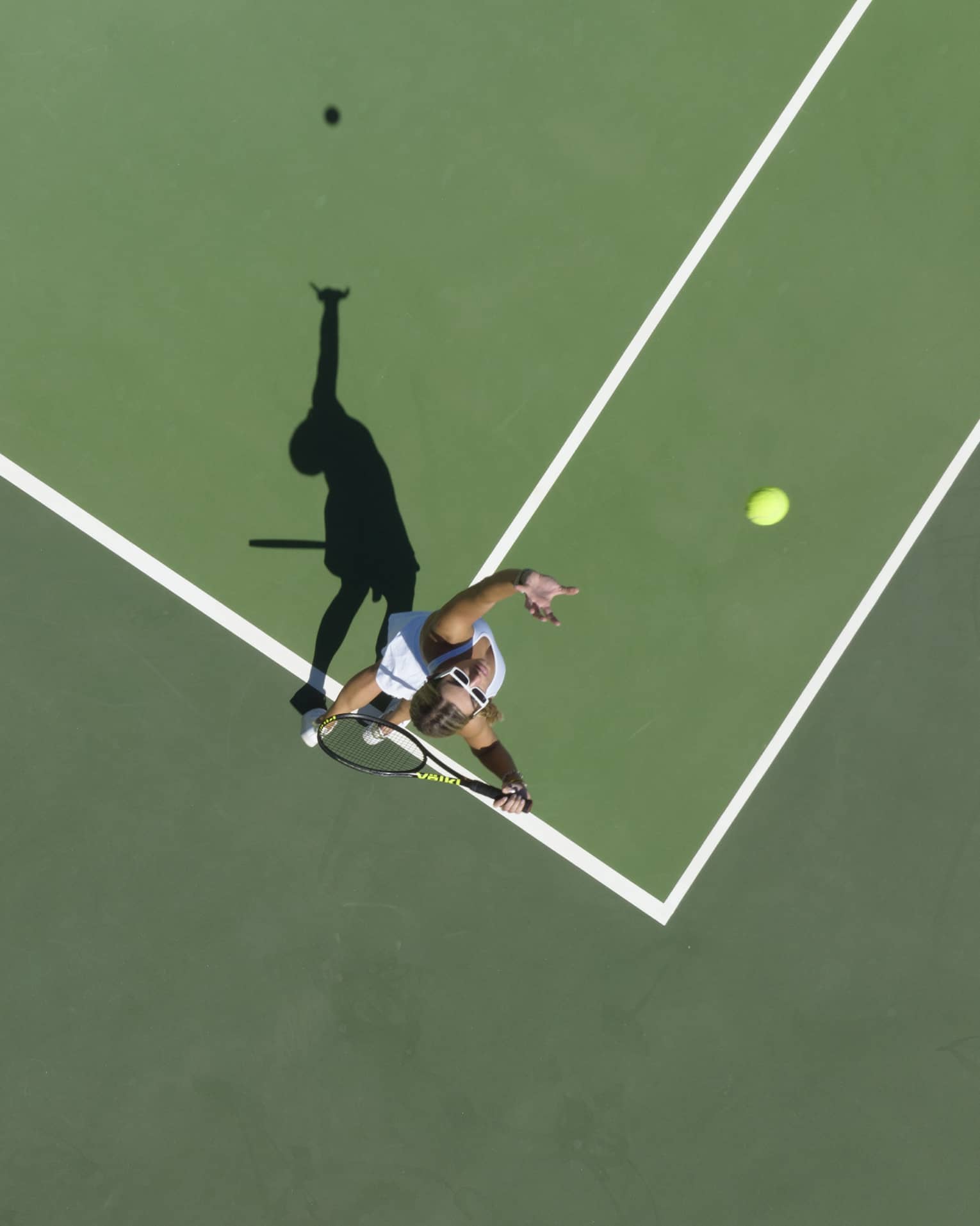 Aerial view of a tennis player mid serve