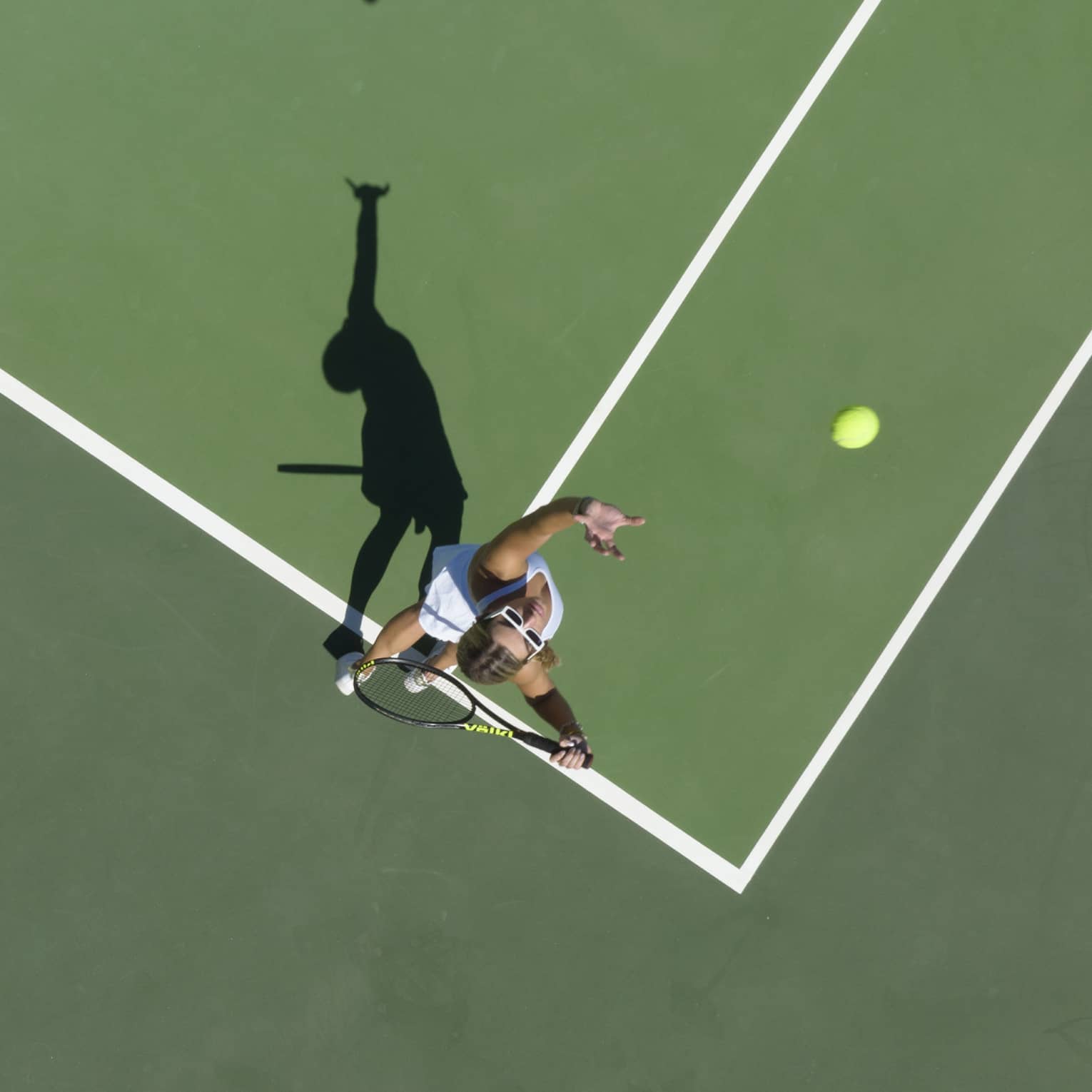Aerial view of a tennis player mid serve