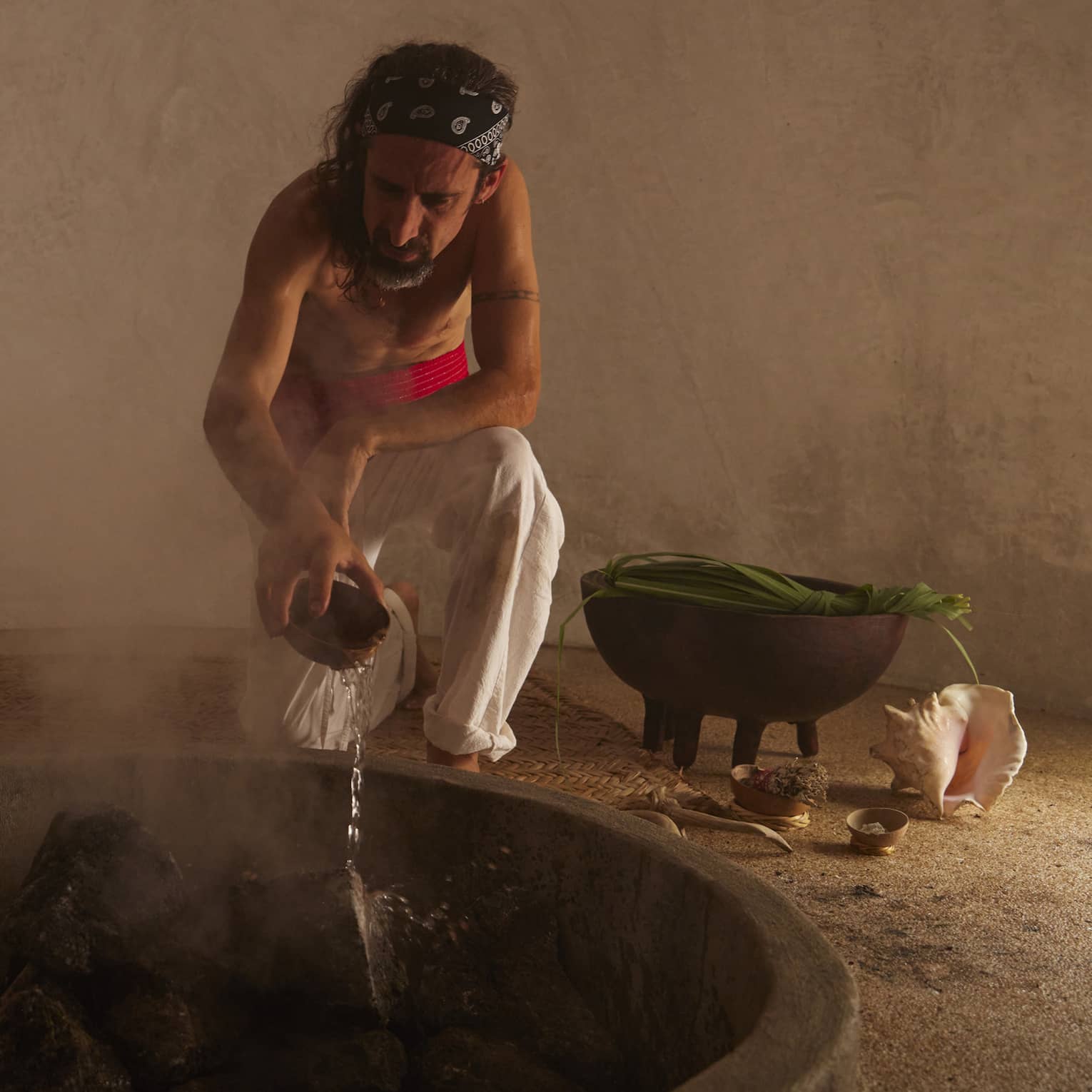 Man tends to a fire in a traditional temezcal or "house of heat"