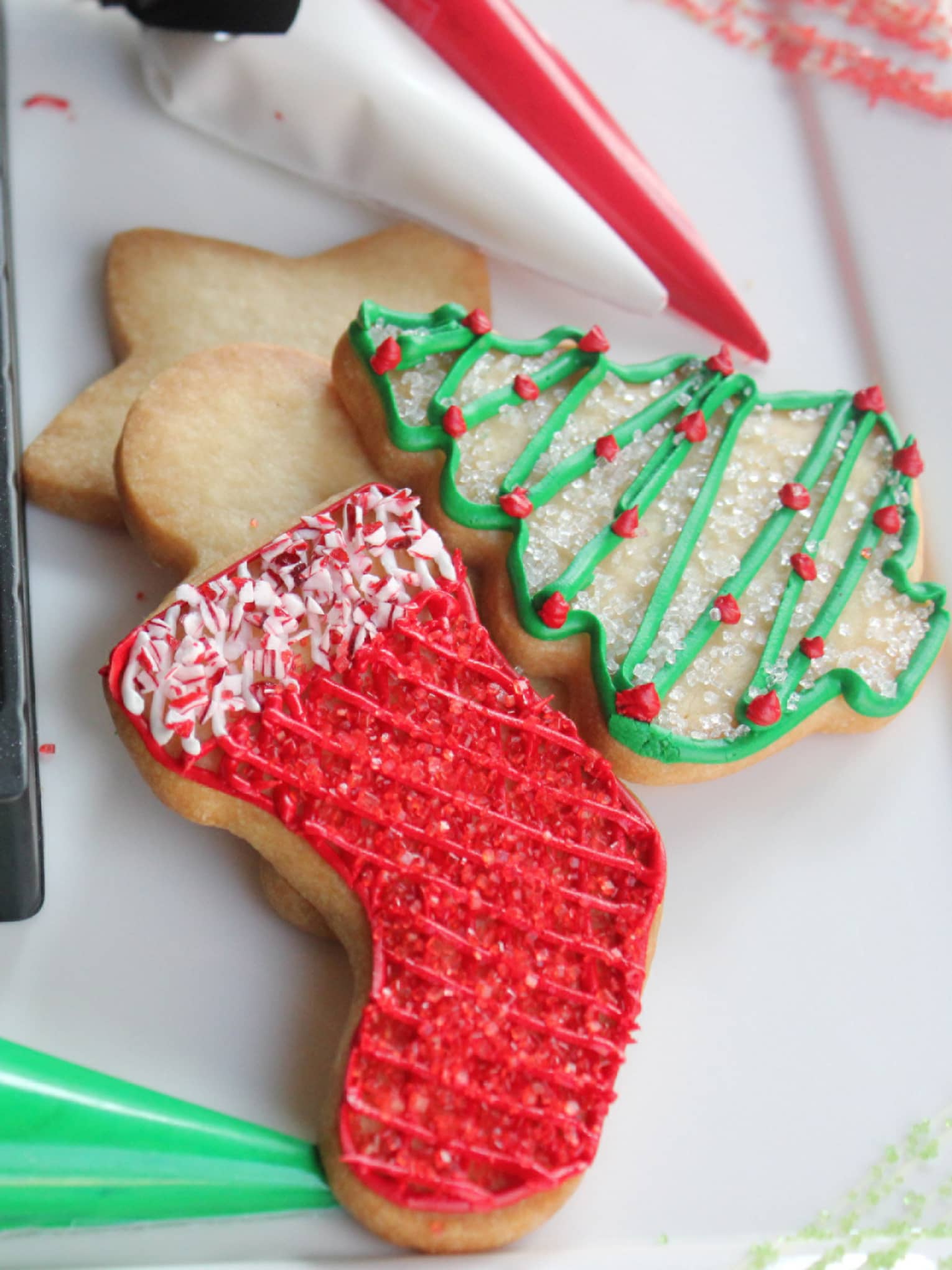 Stocking, christmas free and star-shaped Sugar cookies with sprinkles, icing and chocolate chips next to them