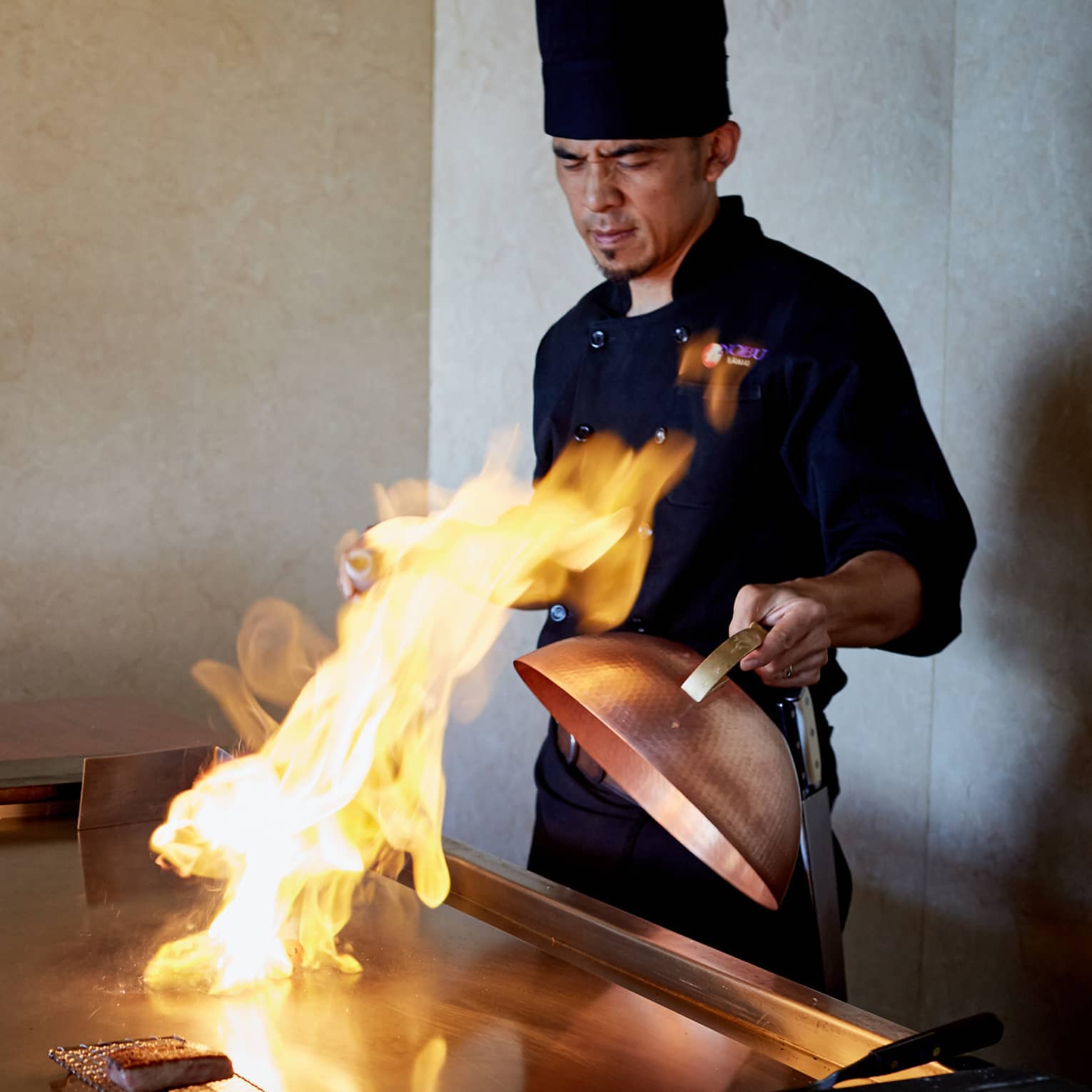 Flames shoot up from grill as NOBU restaurant chef pulls back copper lid
