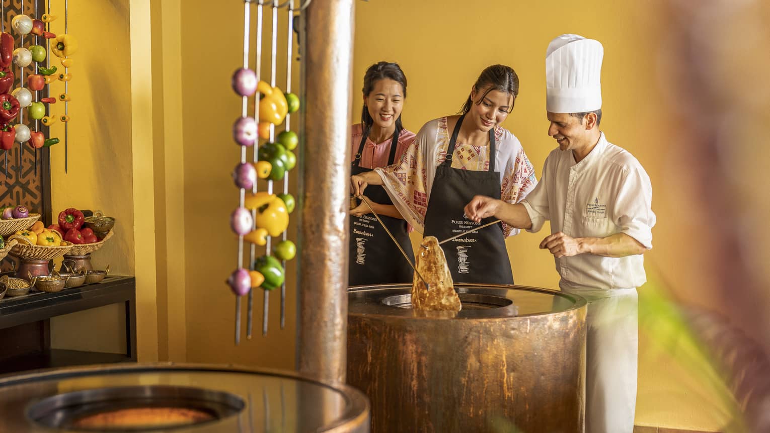Chef teaches two female guests during Indian cooking class at Baraabaru