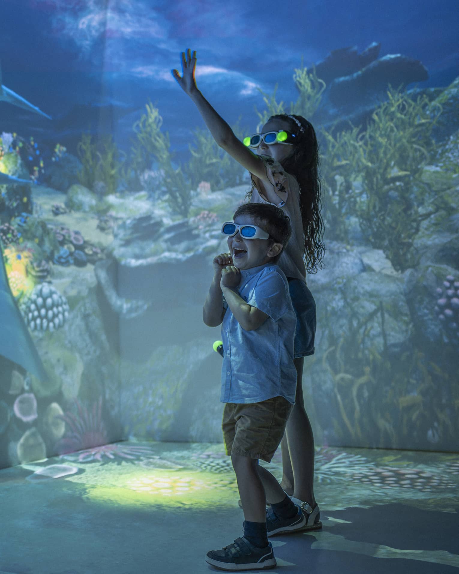 Young girl and boy wearing 3D glasses in the Hologram Room at the Marine Discovery Centre