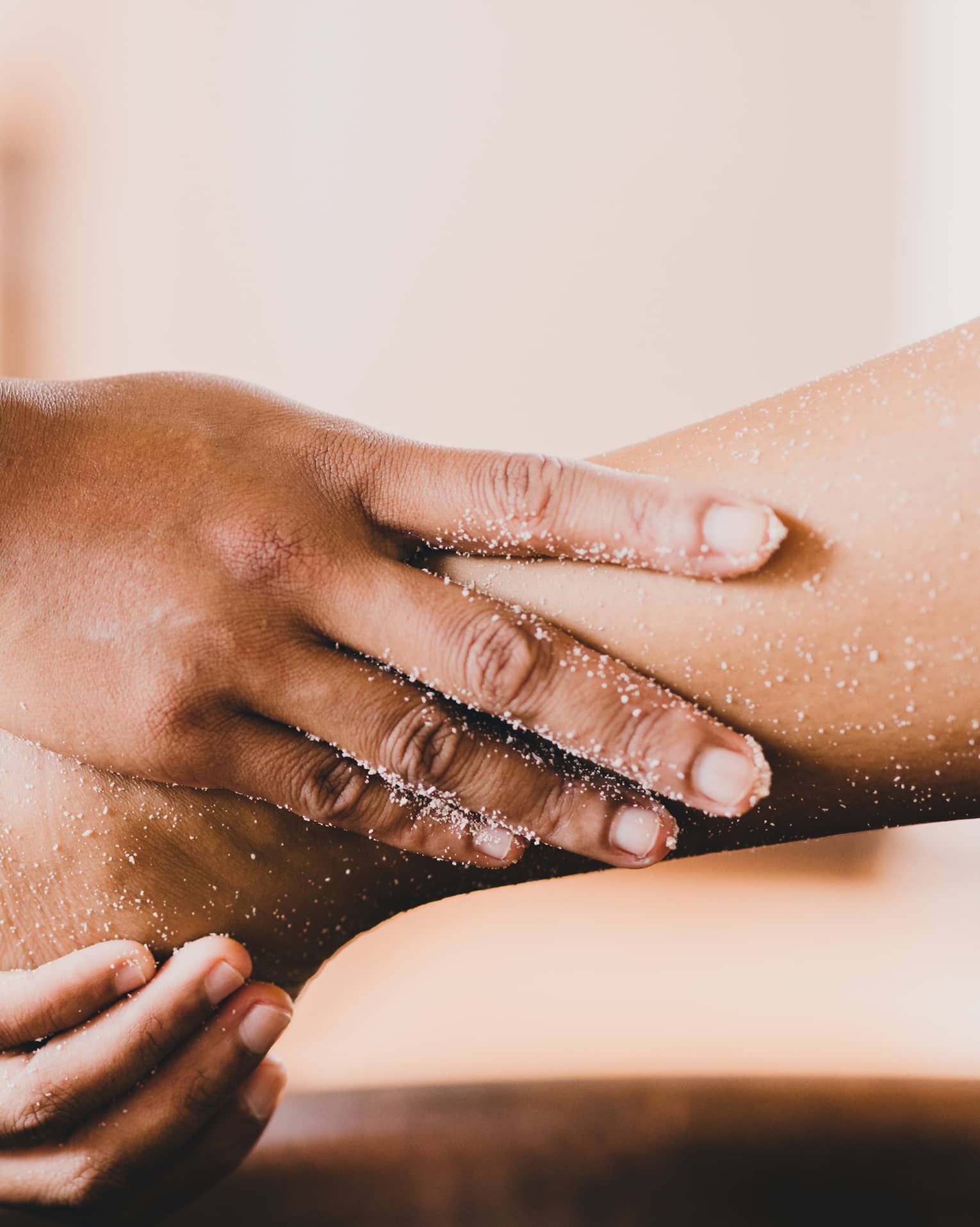 Hands hold a person's foot and ankle in a spa