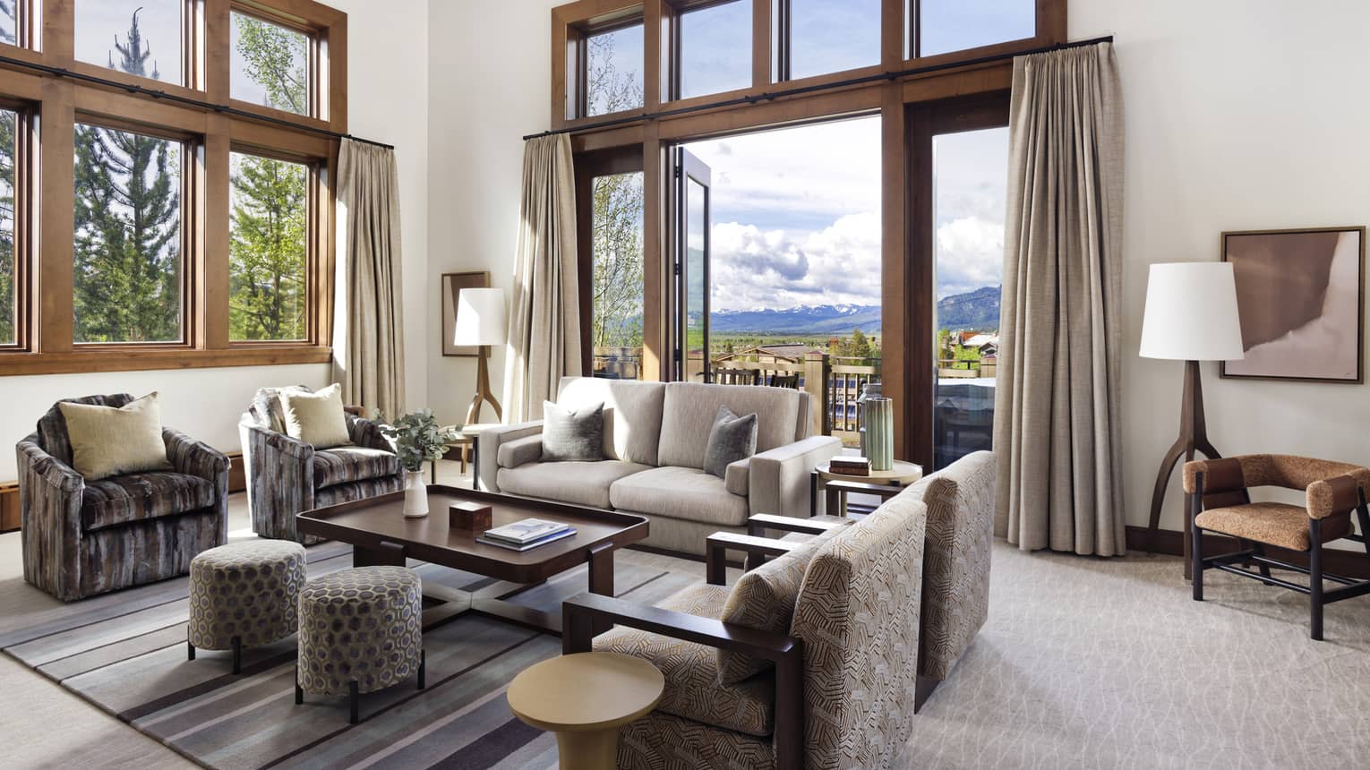Living room with sofa and four arm chairs, two-storey ceilings, walk-out terrace