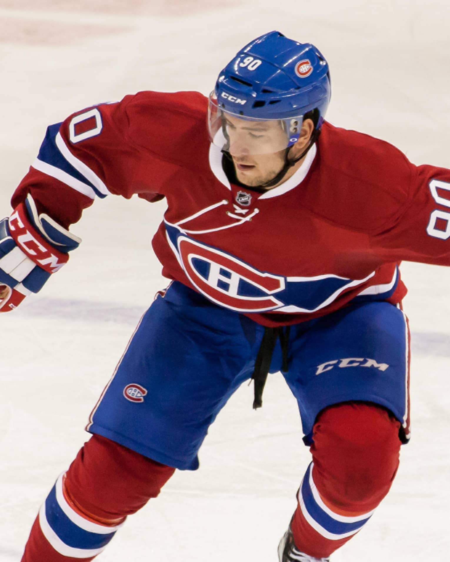 Montreal Canadiens NHL hockey player skates on ice with stick, puck