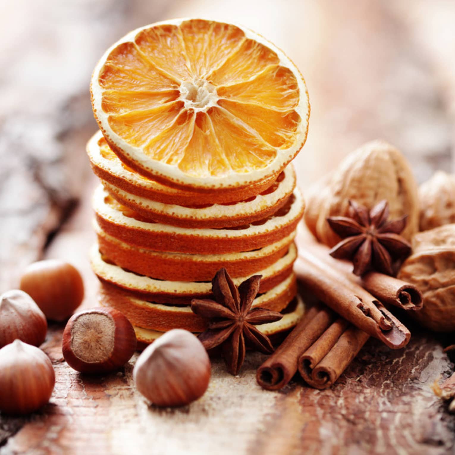 Nuts, spices and orange slices on wood.