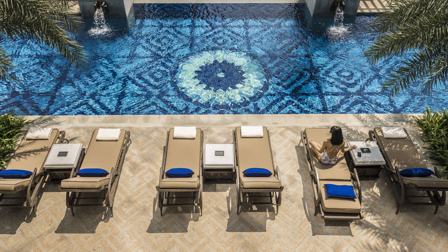 Aerial view of two patio lounge chairs and outdoor swimming pool deck