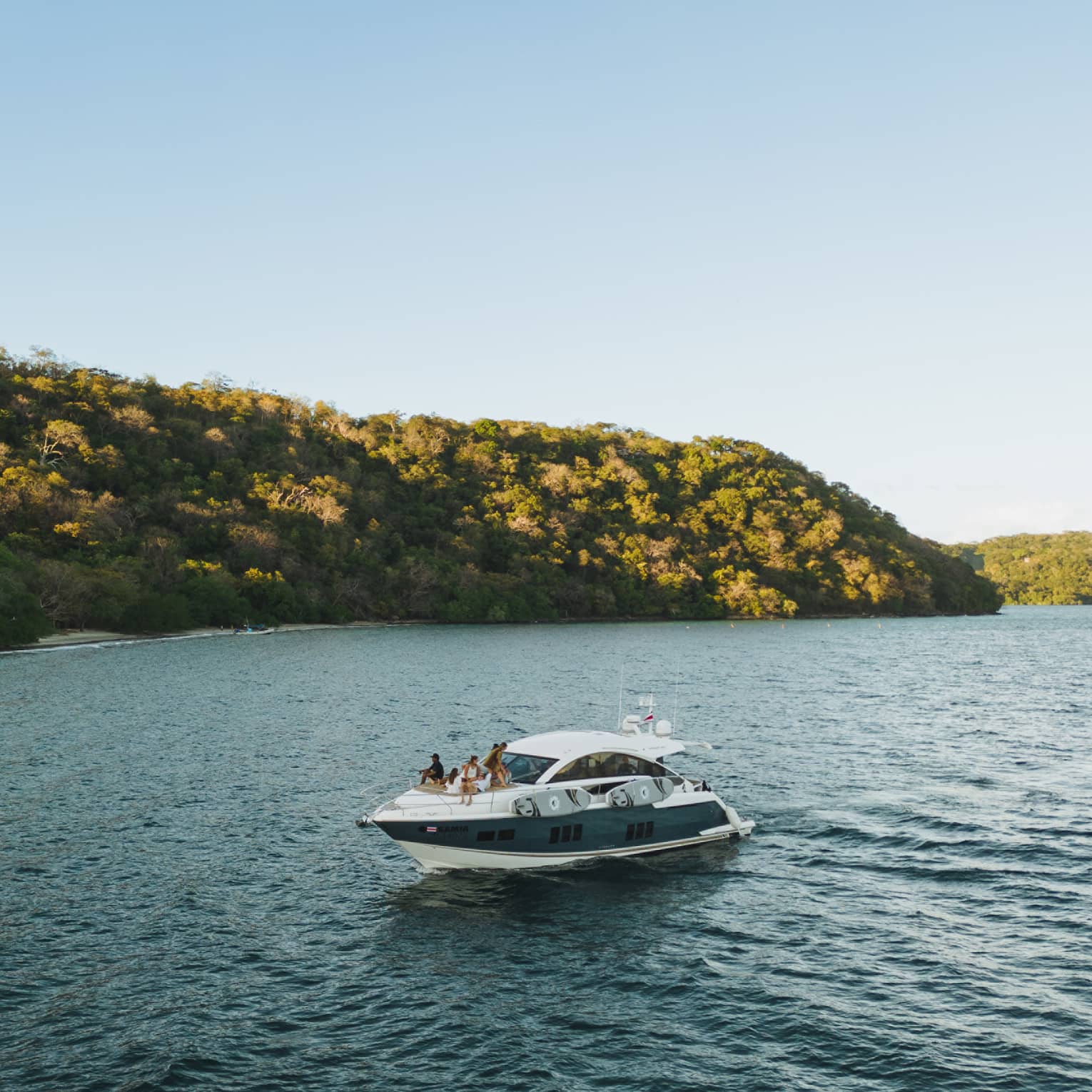 Power boat on water near green hills