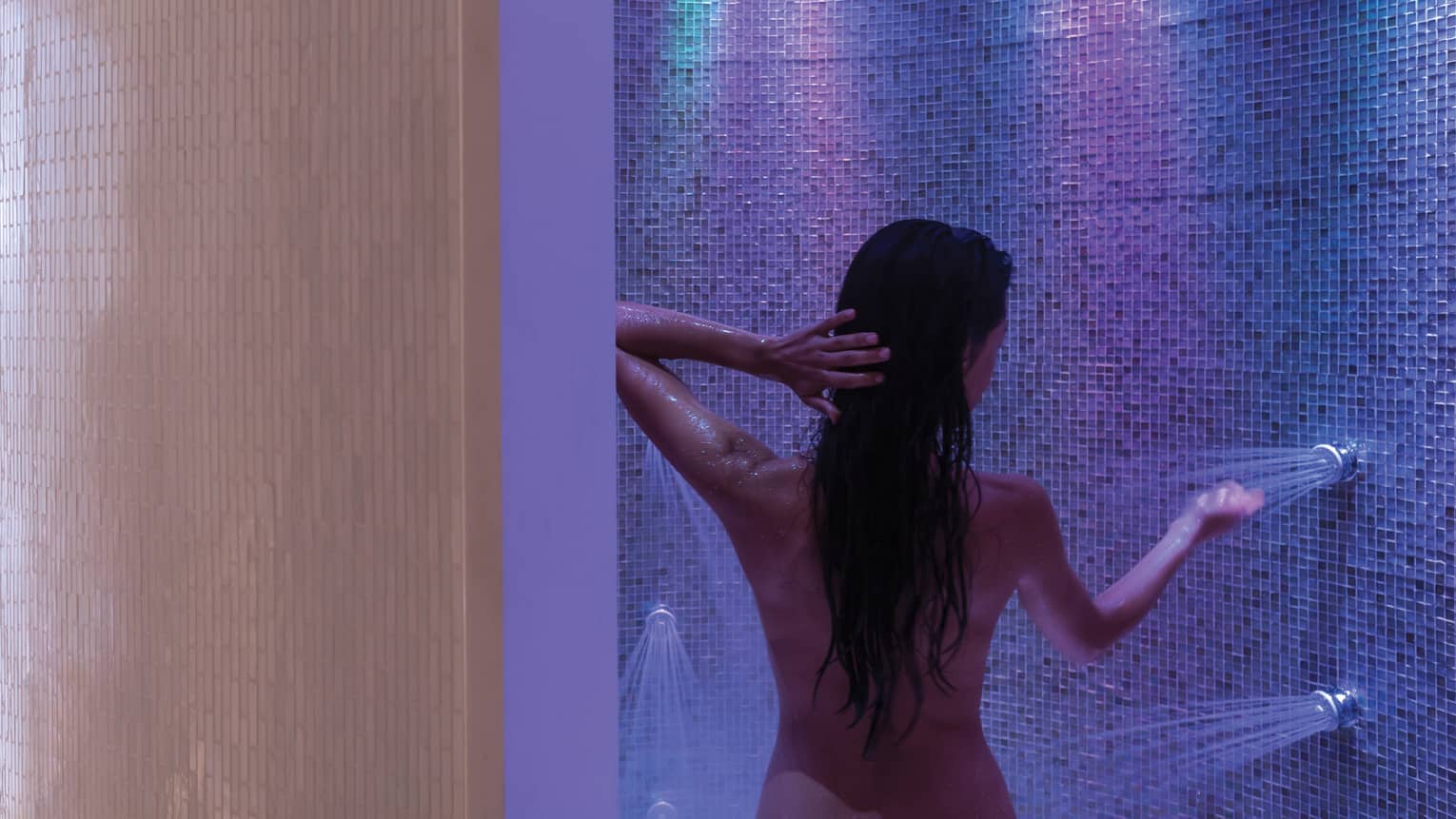 Back of woman in modern spa shower with lights