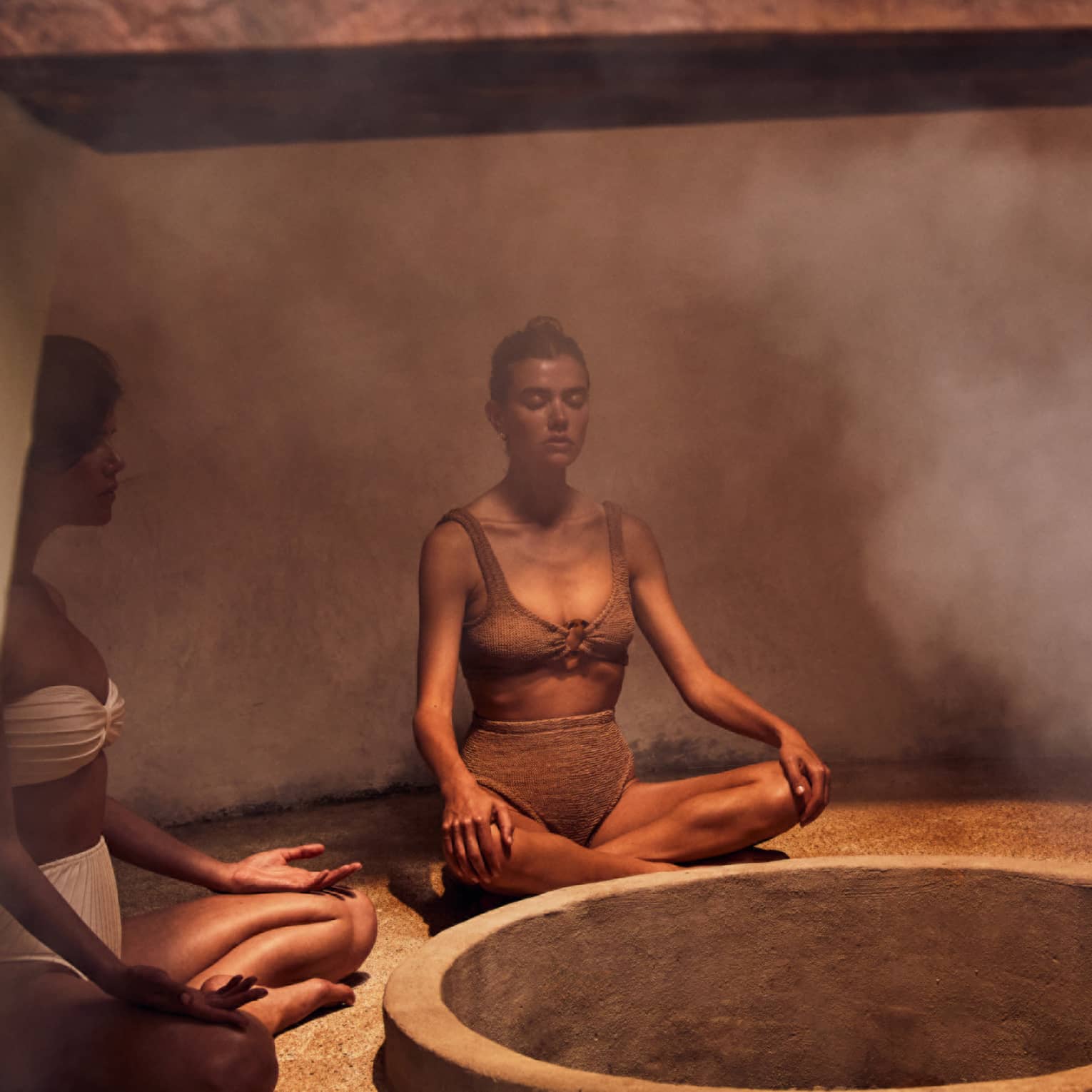 Three people sitting in a heated room with steam.