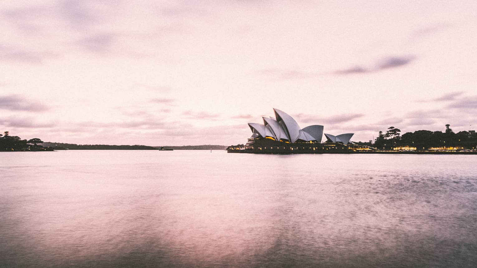 Sydney Harbour's iconic Opera House building on water, pink hue
