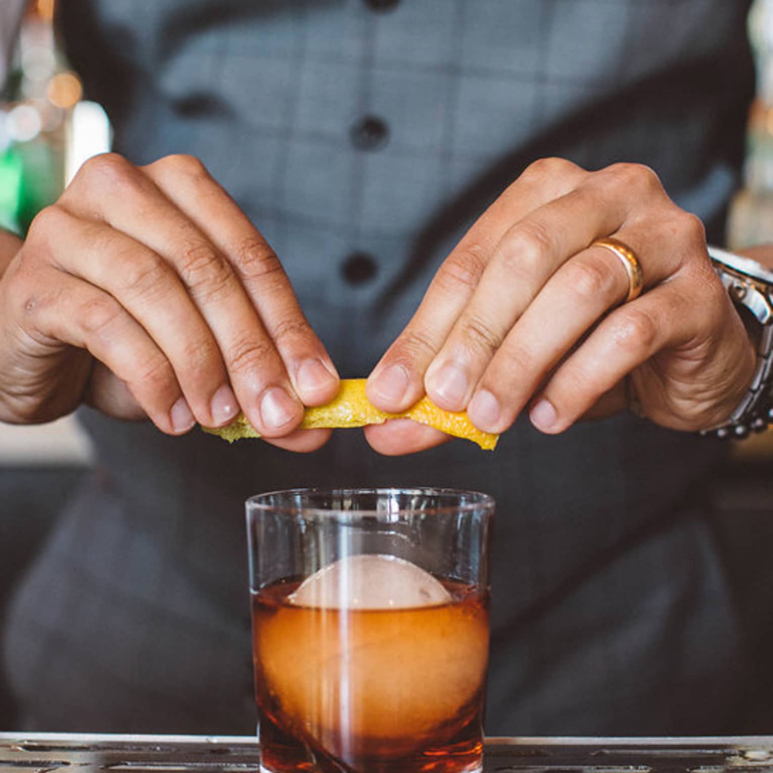 A bartender garnishing a cocktail.