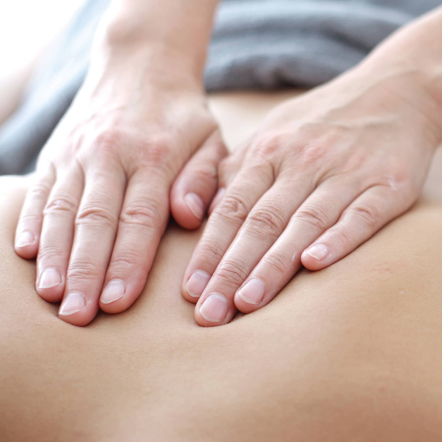 Hands massaging bare shoulders, back