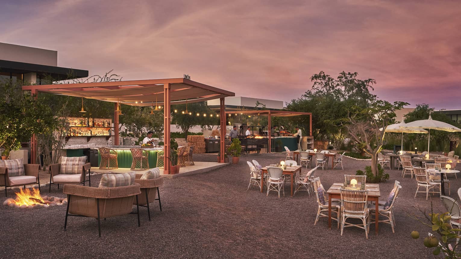 An outdoor eating area with a pink and blue sky above.