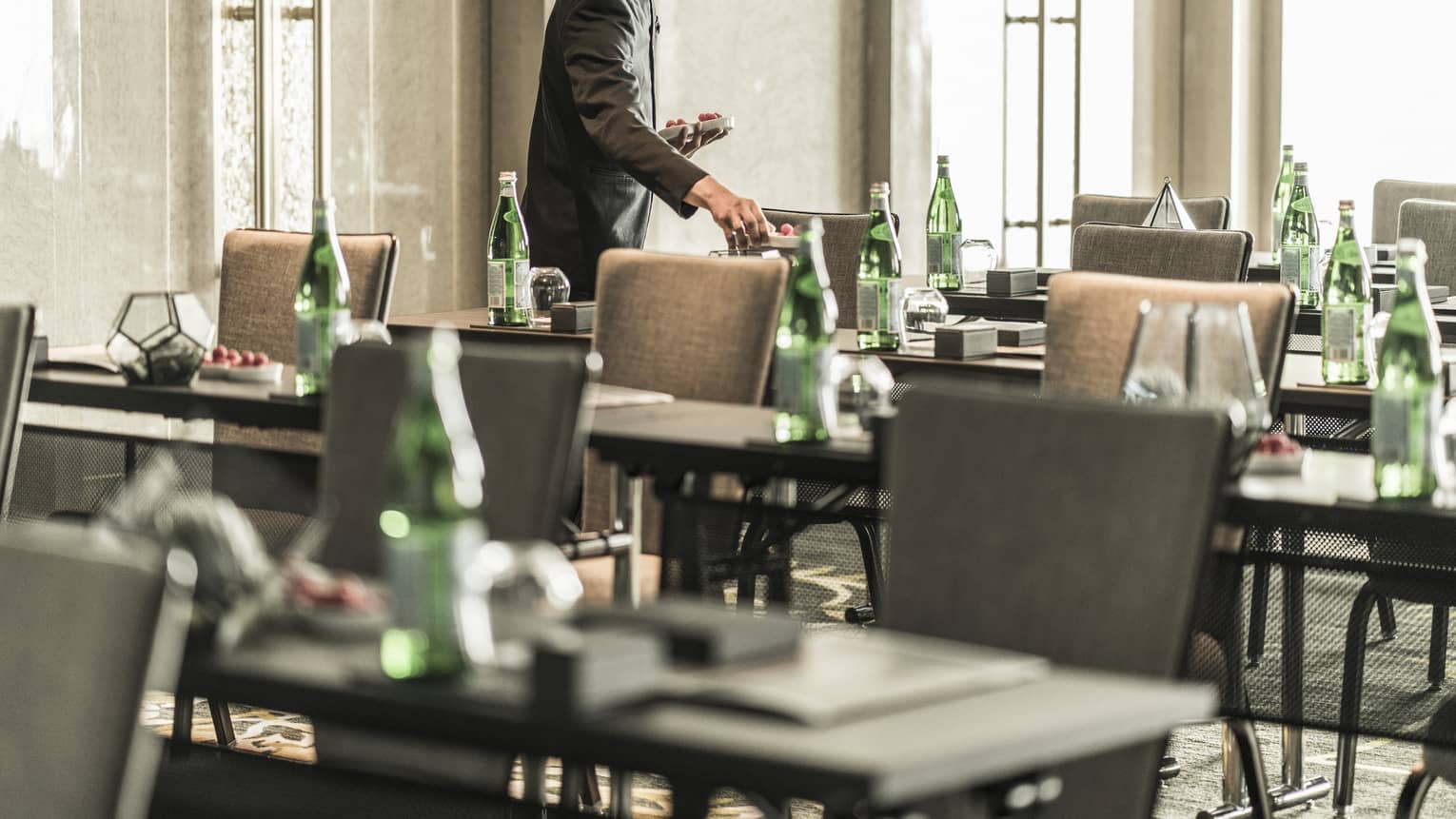Hotel staff sets rows of conference meeting tables in sunny Junior Ballroom 