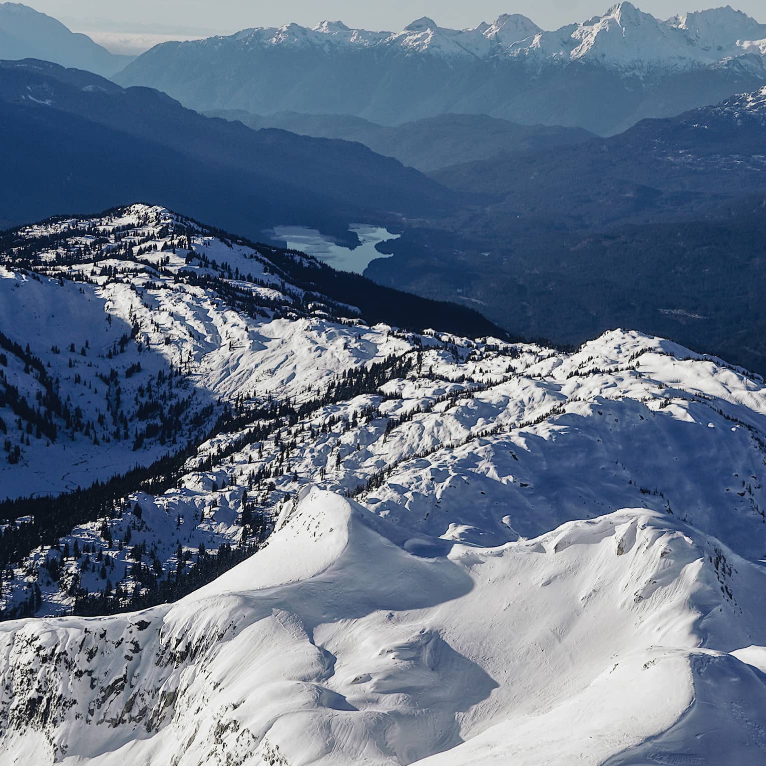 Summit view of snow-covered Coast Mountains