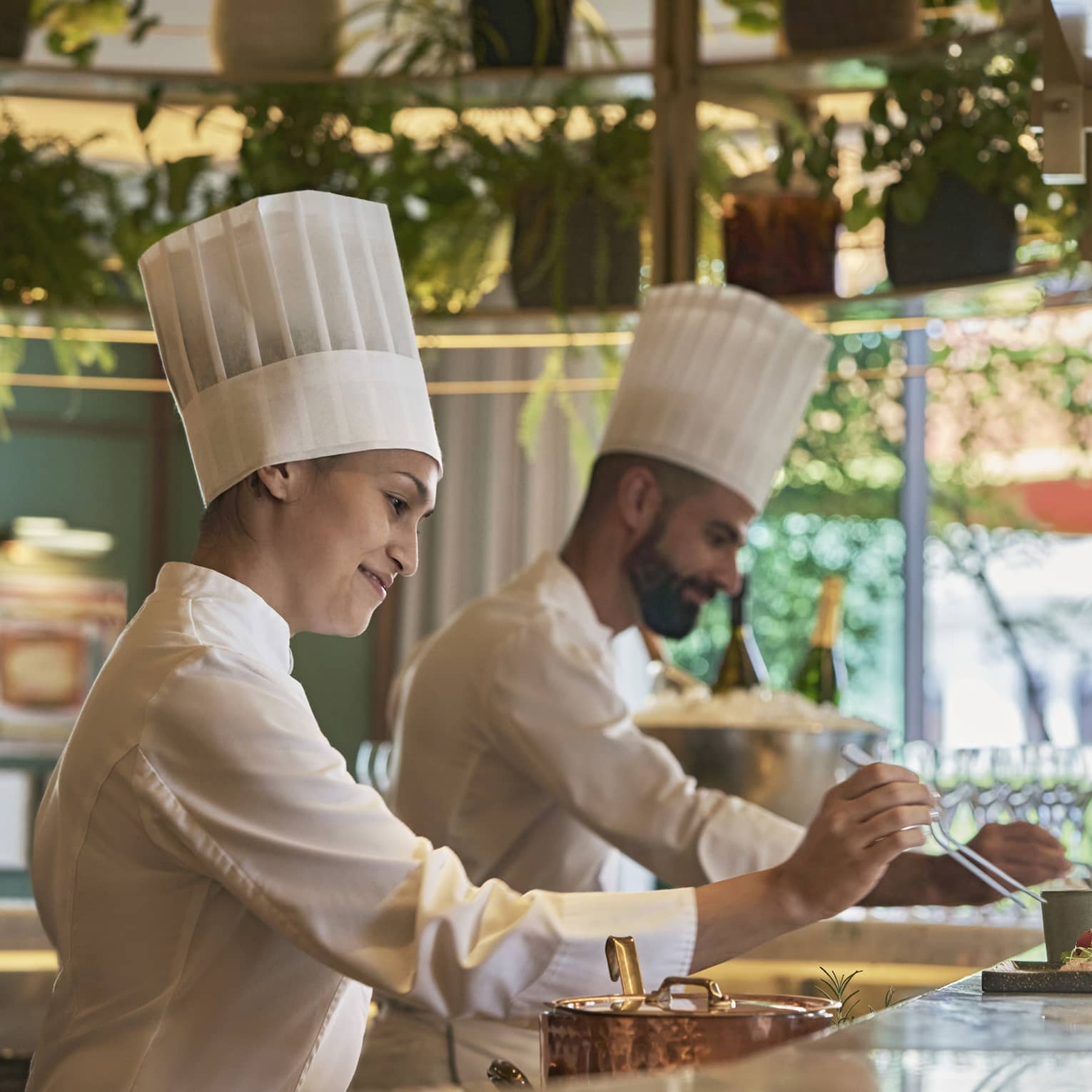 Male and female chef in action at bar counter of restaruant