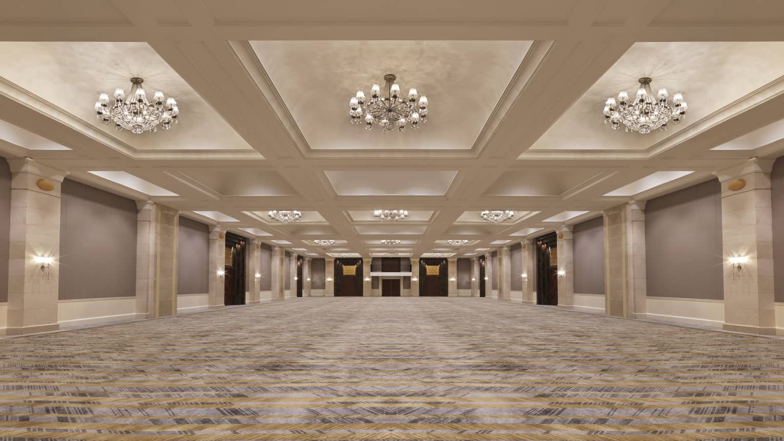 A large function room showcasing the crystal chandeliers in the ceilings.