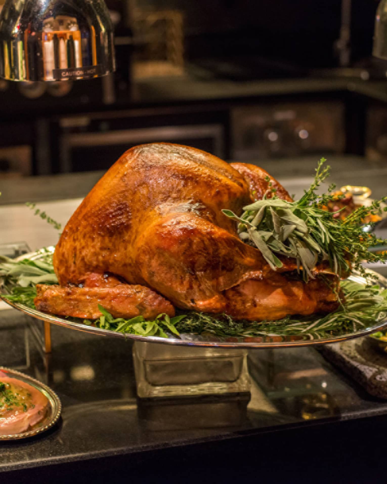 A variety of thanksgiving style good including turkey, sweet potatoes, vegetables, and more.