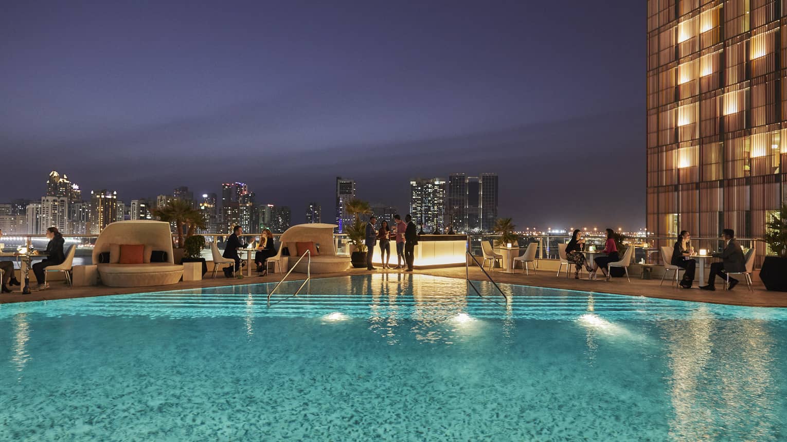 People gather around Eclipse pool at night 