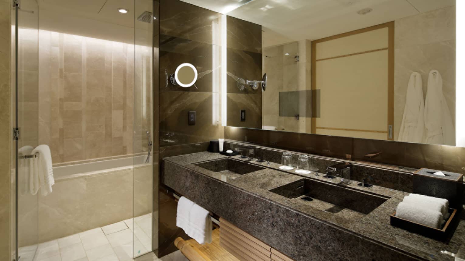 Bathroom with dark marble double vanity, walk-in shower and deep soaking tub