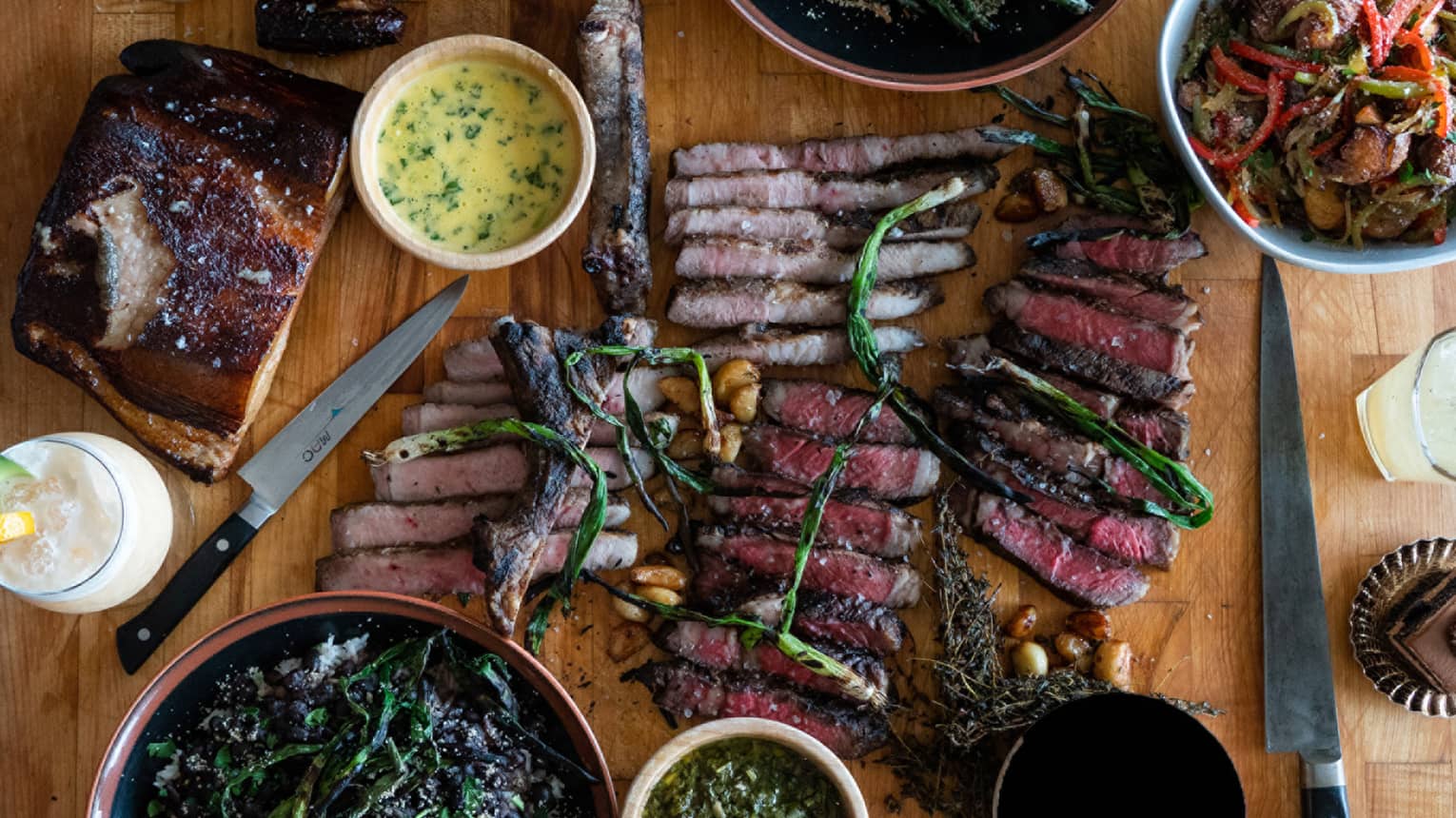 Aerial view of sliced barbecue meats, smoked chicken, vegetables on counter