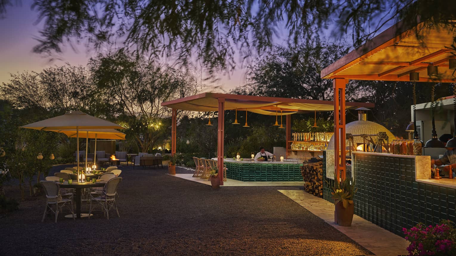 Outdoor dining with umbrellas at sunset.