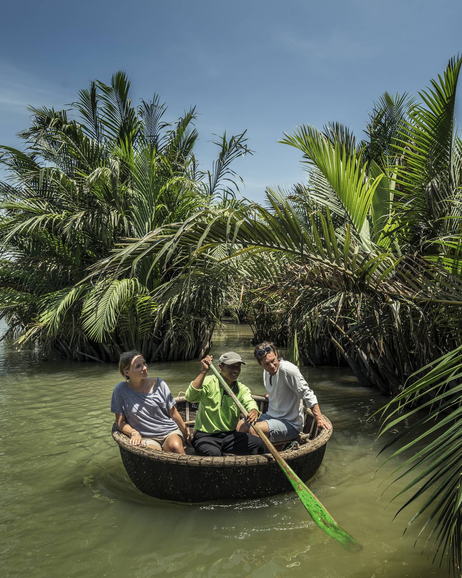 A couple and a guide in a Hoi An tour basket boat
